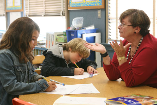 Palisades Elementary teacher's aide Bobbie Farberow works with third-graders Georgia Clay, 8, and Alex Bird, 9, on their imaginary stories. Farberow, the former owner of Mort's Deli, works at the school as a way to stay active in retirement.